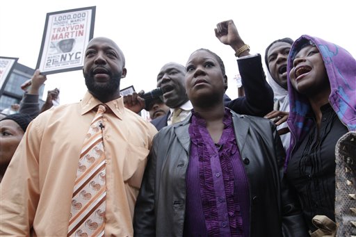 Trayvon Martin's parents, Tracy Martin, left, and Sybrina Fulton, center, are joined by an unidentified woman during the Million Hoodie March in Union Square Wednesday in New York.