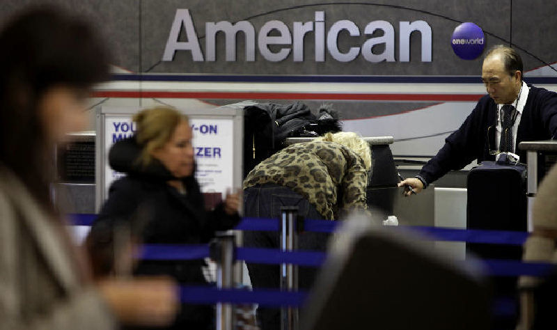Travelers check in at an American Airlines counter at LaGuardia Airport in New York. Air fares will remain high for at least a decade, the FAA predicts, because with little existing competition, airlines have no incentive to lower prices. (AP Photo)