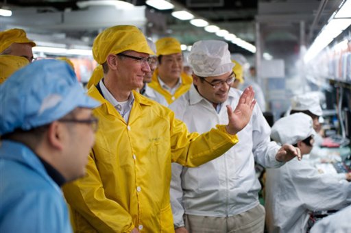 Apple CEO Tim Cook, center, visits the iPhone production line on Wednesday at a newly built manufacturing facility in Foxconn Zhengzhou Technology Park that employs 120,000 people. A report released today by the Washington-based Fair Labor Association says Hon Hai Precision Industry Co., the Taiwanese company that runs Apple's factories in mainland China, has committed to reducing weekly work time to the legal Chinese maximum of 49 hours.