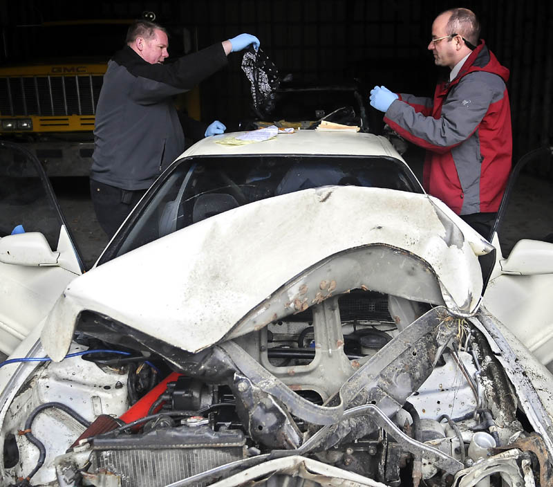 SIFTING THROUGH EVIDENCE: Kennebec County Sheriff’s Dept. Det. Dave Bucknam, left, inspects a black bandana that Det. Sgt. Frank Hatch recovered Thursday from a vehicle in Augusta. Lucas Creamer rolled over the vehicle Wednesday in Readfield while being pursued by police. Creamer was arrested following a brief struggle with officers and is being held in connection with the armed robbery of the Weathervane Restaurant in Readfield. The suspect was described as wearing a mask and carrying a rifle.