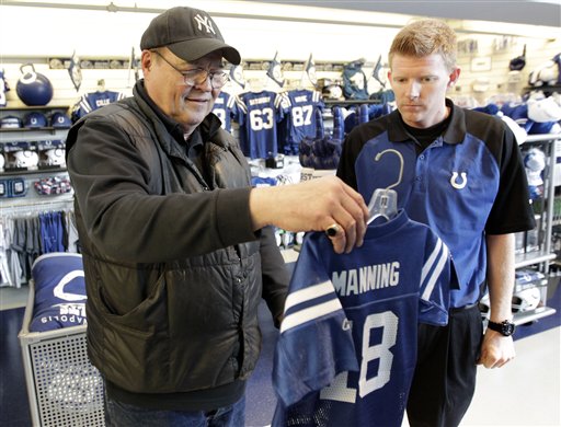 George Krack, of Indianapolis, left, shops for a Peyton Manning jersey for a co-workers child with the help of Colts Pro Shop employee Tyler Robinson in Indianapolis on Wednesday.