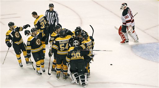 Boston Bruins center David Krejci is surrounded by teammates as New Jersey Devils goalie Martin Brodeur (30) skates off the ice after Krejci's game-winning goal during overtime of an NHL hockey game in Boston, Thursday, March 1, 2012. The Bruins won 4-3. (AP Photo/Charles Krupa)