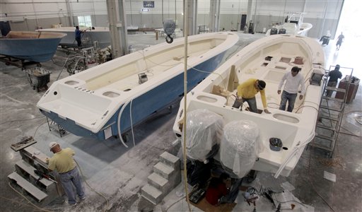 In this Jan. 11, 2012, photo, boat builders work on SeaHunter hulls at SeaHunter Boats in Princeton, Fla.
