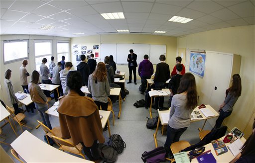 Unidentified pupils of the Anne-Franck college in Lambersart, northern France, and their class teacher Laurie Larvent, center, hold a minute of silence in their classroom today, the day after a gunman on a motorbike opened fire at a Jewish school in Toulouse, killing a rabbi and his two young sons as they waited for a bus, then chased down a 7-year-old girl, shooting her dead at point-blank range.