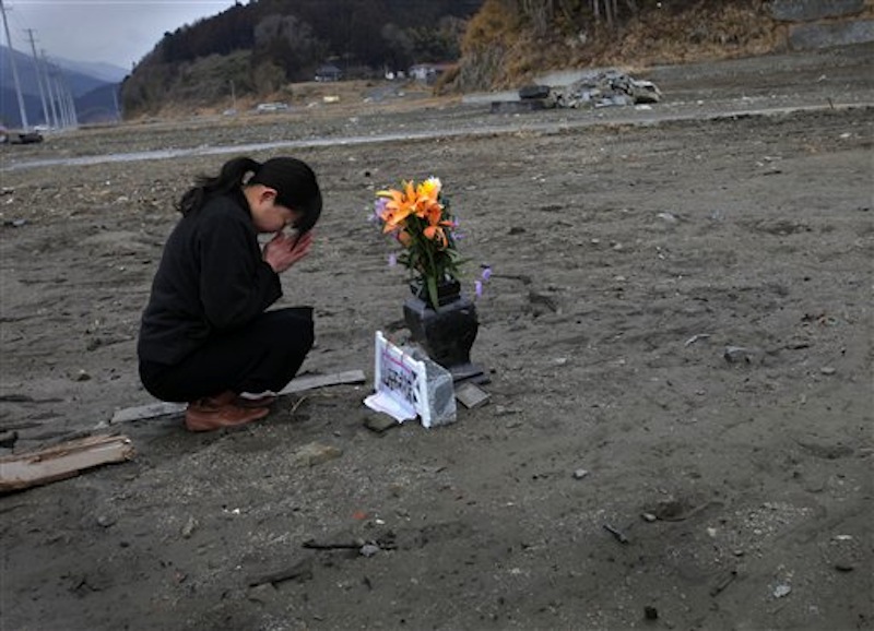 Mika Hashikai, 37, mourns for her mother and father, victims of the March 11, 2011 earthquake and tsunami, in Rikuzentakata, Iwate Prefecture, northeastern Japan on Sunday, March 11, 2012. On Sunday, Japan marks the one-year anniversary of the March 11 earthquake and tsunami that triggered a nuclear crisis.(AP Photo/Itsuo Inouye)