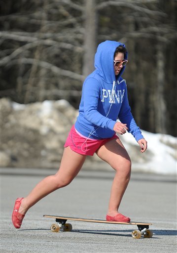 Vinni Nesin, a student from Lincoln, takes to the asphalt exposed by melting sun with her skateboard at the University of Maine campus in Orono on Wednesday.