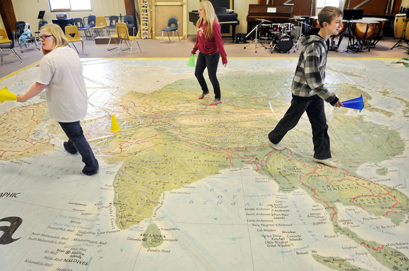 Maranacook Community High School freshman cross a giant map of Asia at the Readfield school.