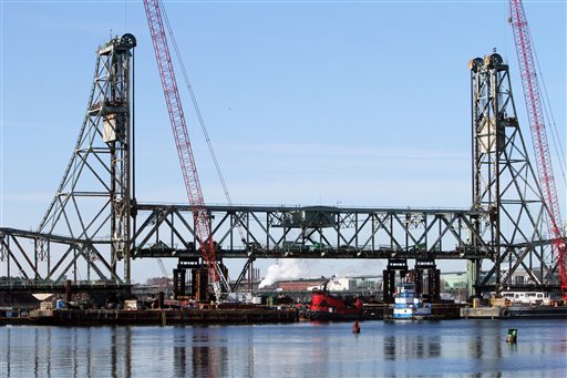 The 2 million pound lift span of the historic Memorial Bridge, connecting New Hampshire to Maine, is slowly dropped into a cradle on a barge, Wednesday, Feb. 8, 2012 in Portsmouth, N.H. The bridge is scheduled to be replaced by the summer of 2013. (AP Photo/Jim Cole)