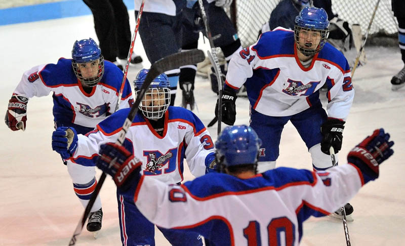 Messalonskee High School's Joshua Towle, 3, center facing, celebrates a first period goal against Presque Isle High School with teammates William Blake, 8, back left, Kalib Bernatchez, 21, back right, and Corey Foye, 10, foreground in the eastern regional play-off game at Sukee Arena in Winslow Saturday.