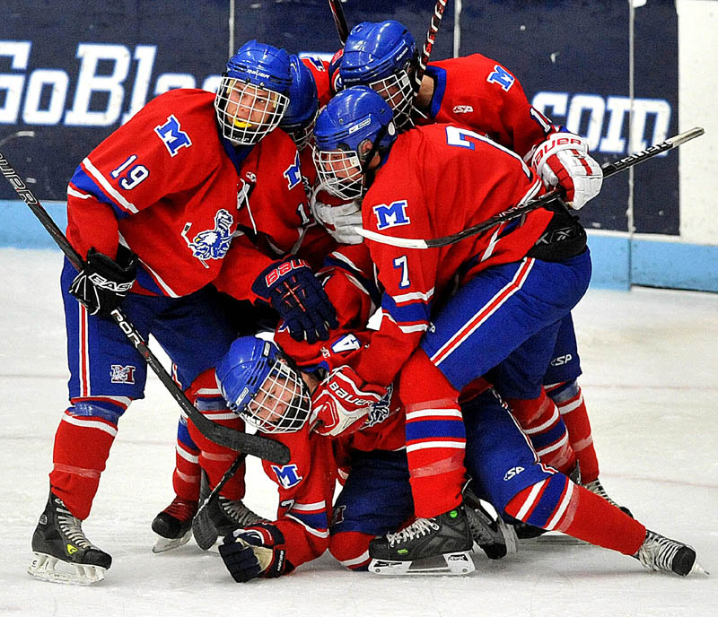Photo by Michael G. Seamans Messalonskee High School celebrates a goal by Chase Cunningham, 12, center, in the first period of the Class B East hockey regional finals at Alfond Arena at the University of Maine in Orono Tuesday night.