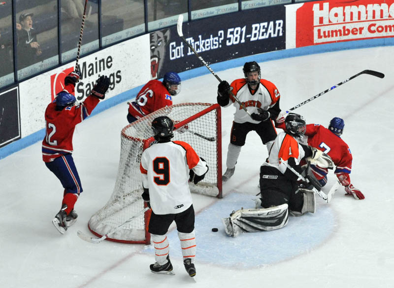 Photo by Michael G. Seamans Sam Dexter, 7, right, slides past the goalie after a goal in the second period of the Class B East hockey regional finals at Alfond Arena at the University of Maine in Orono Tuesday night.