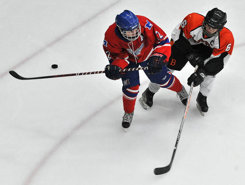 Photo by Michael G. Seamans Messalonskee High School's Chase Cunningham, 12, right, and Brewer High School's Jacob Chapman, 6, battle for the puck in the second period of the Class B East hockey regional finals at Alfond Arena at the University of Maine in Orono Tuesday night.