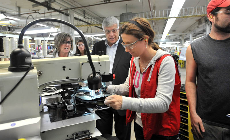 Rep. Mike Michaud, center, speaks with New Balance factory employee Tiffany Whitney while touring the New Balance shoe factory in Norridgewock this morning. Rep. Michaud toured the plant and picked up a pair of size 12D running shoes for President Obama.