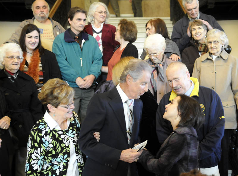 Augusta resident Leo Pepin, center, is congratulated by relatives Monday after Gov. Paul LePage signed a bill designating a tune Pepin wrote, the "Dirigo March," as the state marching song at a State House ceremony in Augusta.