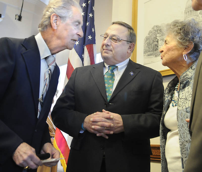 Augusta resident Leo Pepin, left, and his sister, Madeline Patnaude, speak with Gov. Paul LePage after LePage signed a bill Monday designating a tune Pepin wrote, the "Dirigo March," as the state marching song at a Statehouse ceremony in Augusta.