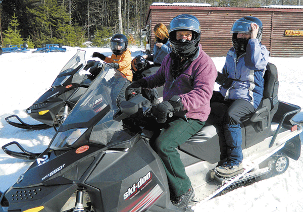 The gang heads out on snowmobiles, available for rental at Twin Pine Camps.