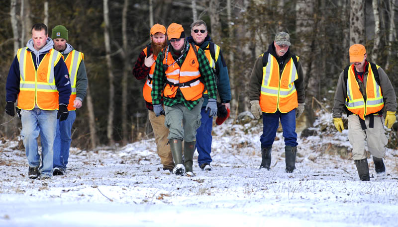 IN FORCE: Volunteer searchers hike through a field Thursday morning in Dresden near the Eastern River while looking for 12-year-old Micah Thomas.