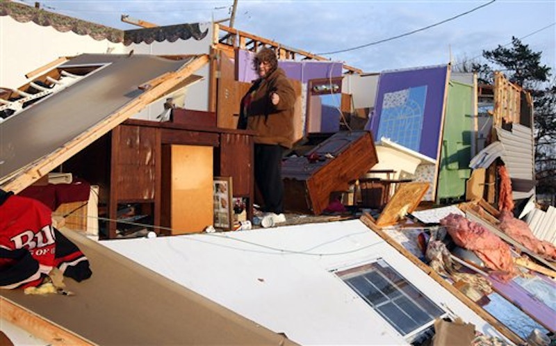 Judy Taylor surveys the damage to her trailer home on Carlisle Road, Piner, KY Friday March 2, 2012 after strong storms ripped through the area about 25 miles south of Cincinnati, OH. (AP Photo/The Enquirer)