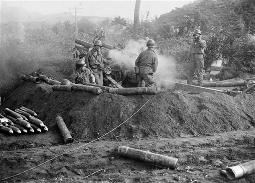 In this July 10, 1950, photo, American GIs fire a 105 mm Howitzer in action against North Korean invaders somewhere in Korea.