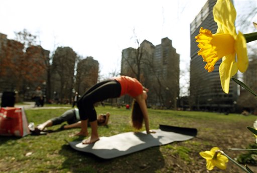 Danielle DelVecchio, left, takes pictures of Aileen Palmer as Palmer does yoga near the flowers in bloom in Rittenhouse Square in Philadelphia on Tuesday.