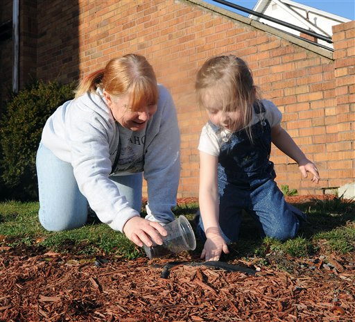 Debbie Sailor, left, helps 4-year-old Haedyn Scrannage plant tulip and daffodil bulbs around the Fairmont Free Methodist Church in Fairmont W.Va., on Tuesday. With temperatures climbing into the lower 70s for the first time this season it was a perfect day for planting.
