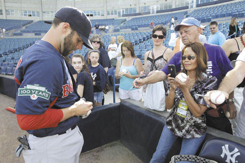 SURREAL: Boston’s Dustin Pedroia signs autographs for fans before a spring training game against the New York Yankees on Tuesday at Steinbrenner Field in Tampa, Fla. Yankees fans — many of whom visited from the New York area — clamored for the Red Sox second baseman instead of shouting obscenities at him.