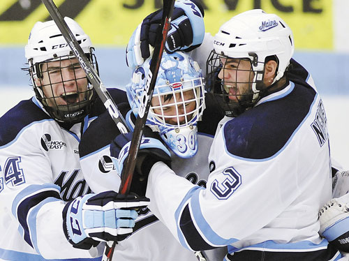 WE DID IT: Maine goalie Dan Sullivan, center, celebrates with Ryan Hegarty, left, and Mark Nemec after defeating Merrimack in a Hockey East quarterfinal game Sunday in Orono.
