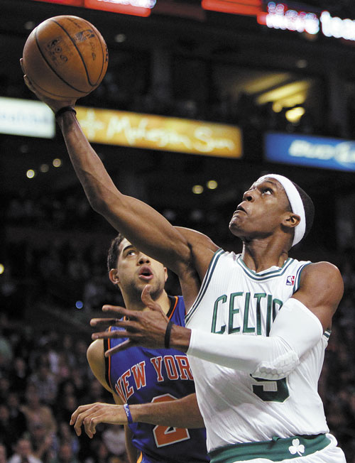 BIG GAME: Boston’s Rajon Rondo (9) shoots in front of New York Knicks’ Landry Fields in the second quarter Sunday in Boston. Rondo had a triple-double as Boston won 115-111 in overtime.
