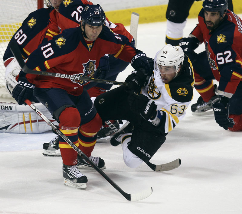 KNOCKED OUT: The Florida Panthers' John Madden, left, and Boston Bruins' Brad Marchand battle for puck during the second period Thursday night in Sunrise, Fla. Florida scored three goals during that period alone to pull away for a 6-2 victory.