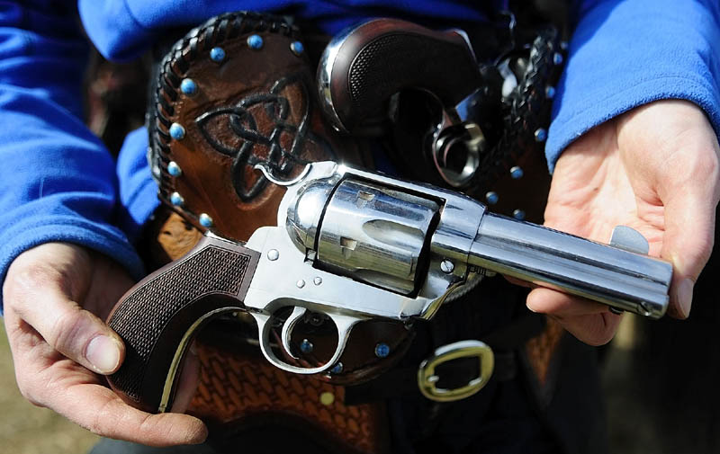 SIDE ARM: Sara Bell, of Warren, displays the Pony Express .45 caliber single action revolver she used in the Maine Cowboy Mounted Shooting Clinic on Saturday in West Gardiner. The sports uses .45 caliber single action revolvers like those used in the late 1800's. Single action revolvers must be cocked each time before firing by drawing the hammer back. They fire brass cartridges loaded with black powder and the heat blasting out of the barrel breaks the balloon target.