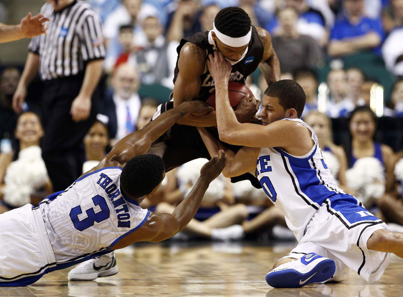 HUSTLE PLAY: Duke’s Tyler Thornton, left, and Seth Curry, right, struggle to pry the ball from Lehigh’s Mackey McKnight during the first half of their NCAA tournament second-round college game Friday night in Greensboro, N.C. Lehigh pulled the upset, winning 75-70. NCAA