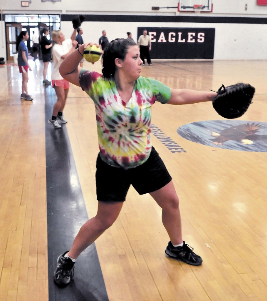 IT’S SPRING AGAIN: Messalonskee High School softball player Emily Nadeau, along with the rest of the pitchers and catchers, warm up during practice Monday in Oakland.