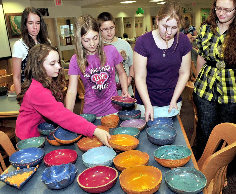 FILL ’EM UP: Skowhegan Middle School students unpack some of the 100 clay bowls they made that will be filled with soup and served with bread from 5:30-7:30 p.m. Friday to benefit area food cupboards. Students from left are Marinel Demmons, back, Samantha Joy, Elizabeth Jones, Andrew Todd, Mariah Bonneau and potter Yvonne Ballenbacher.