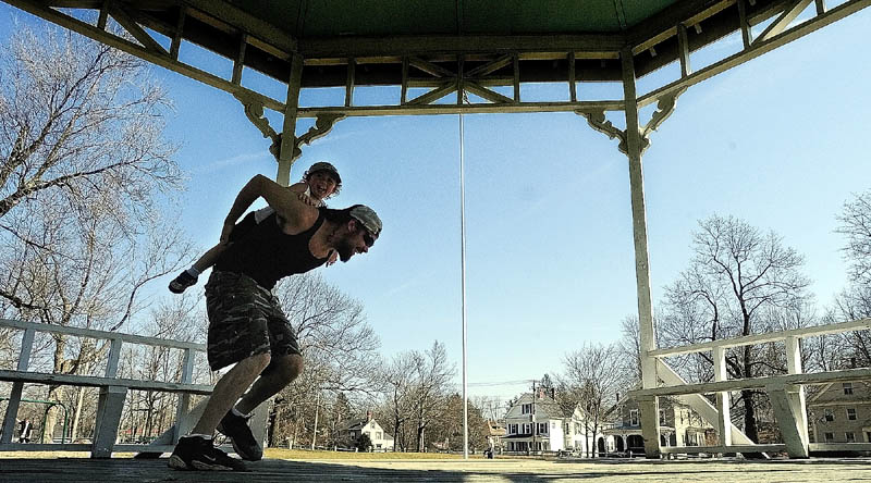 Michael McLaughlin gives his son a piggy-back ride out of the gazebo on a warm sunny Tuesday afternoon in Gardiner. They and many other people enjoyed the warm weather on the first day of spring playing on the playground and exploring the monuments at The Gardiner Common.