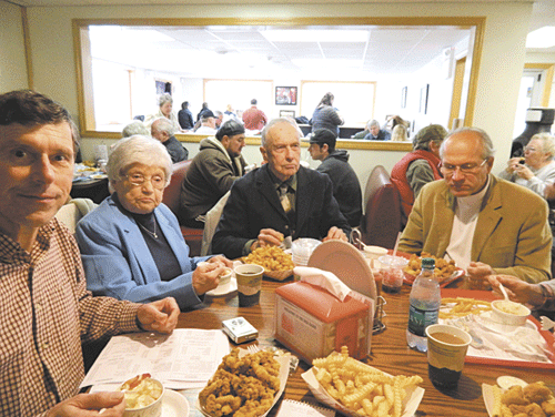 WHAT A FEAST: George Smith, left, samples his Seafood Stew while members of his party enjoy other menu items.