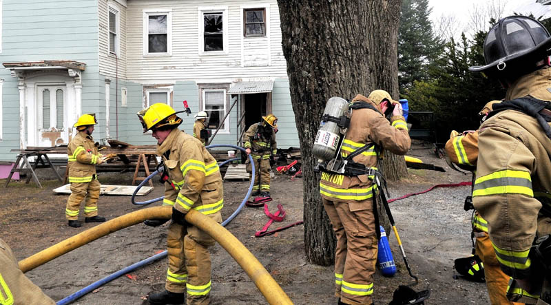 TURNOUT: Firefighters from several area departments haul in water hoses and gear Monday to put out a fire at a home on Church Street in Oakland.