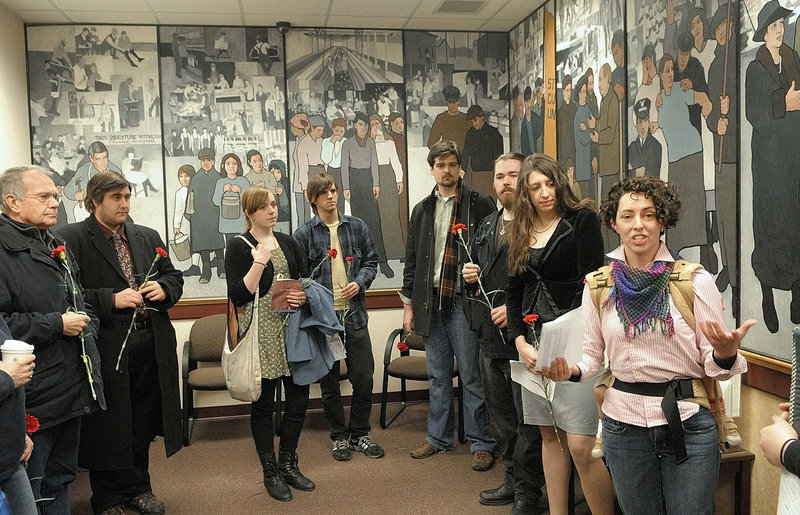 NOT THERE: Jessica Graham, right, leads a gathering last year in front of a mural honoring labor, in the Department of Labor building’s lobby in Augusta. Arguments are expected to be delivered Thursday in Bangor on the state’s motion to dismiss a lawsuit that aims to restore the mural ordered removed by Gov. Paul LePage, who thought it presented a biased view of history.