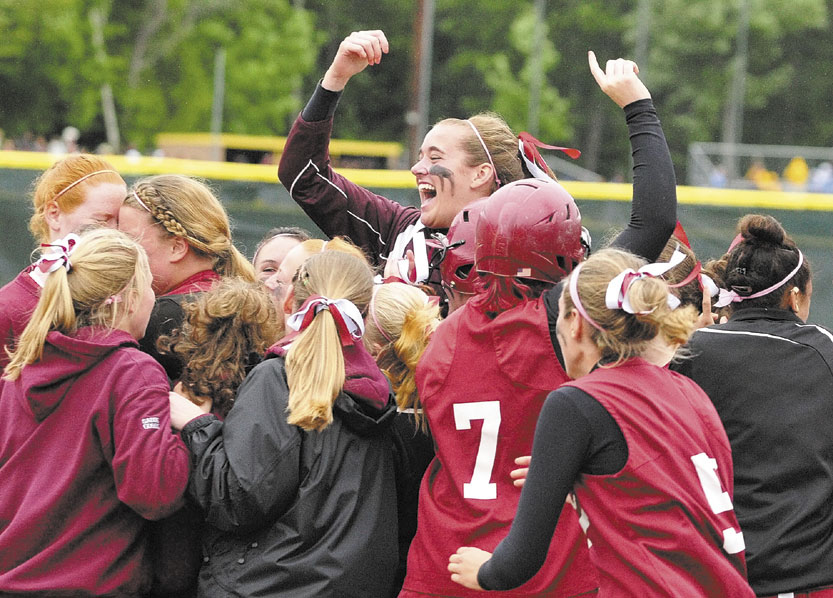 STATE BOUND: Richmond’s Jamie Plummer leaps above her teammates as they celebrate their 3-2 victory over Buckfield in the Western Class D softball championship game last spring at St. Joseph’s College in Standish. The Bobcats’ junior class has one state title and will be looking for another this season.