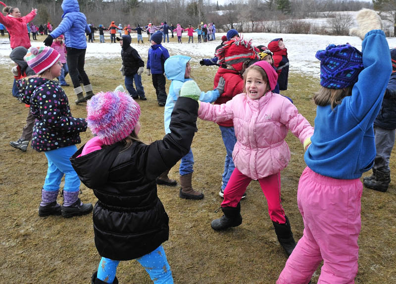 JUMPING JILLS: Bloomfield Academy students Delenn Travers, left front, and Elaine Vanadestine do jumping jack exercises during one of several outdoor events for WinterKids Wellness Day at the Skowhegan school on Thursday. Olympic gold medalist Seth Wescott spoke and encouraged kids to get outside and enjoy winter activity.