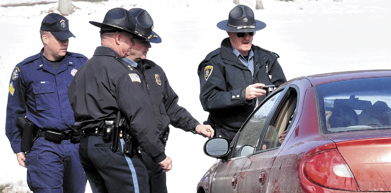 VICTIMS: State and Skowhegan police interview occupants of a car along East River Road in Skowhegan on Wednesday after Alan W. Sipe of Cornville alledgedly fired a handgun at it. No one was injured in the shooting, and Sipe was arrested. Occupant Tara Harrington was reportedly injured in an assault earlier.