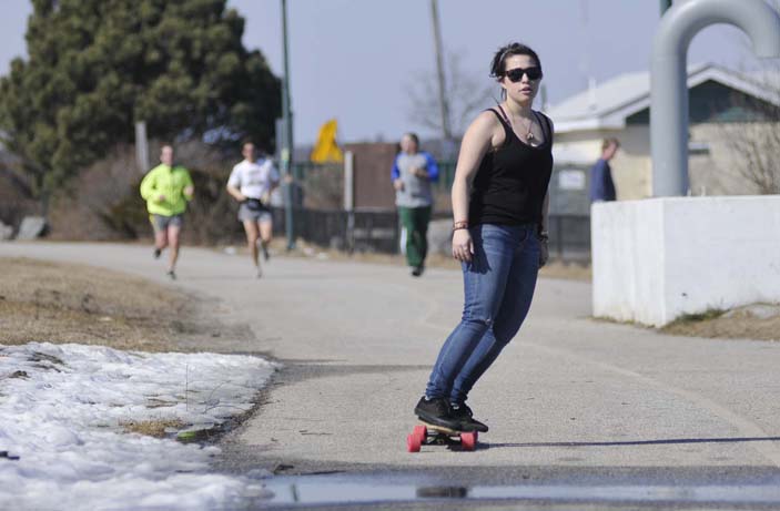 Lauren Collins of Portland takes advantage of today's warm weather by skateboarding along the Eastern Prom Trail in Portland. Collins is a student at Maine College of Art and had some free time before her next class.