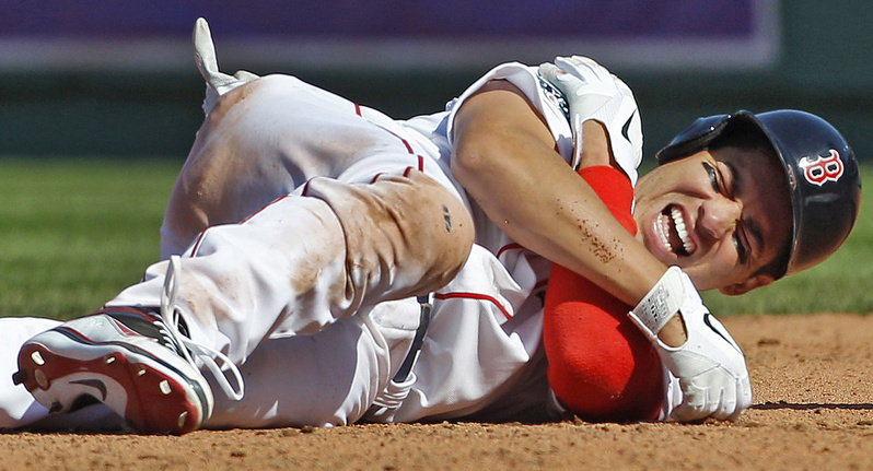 Boston Red Sox' Jacoby Ellsbury grabs his right shoulder after colliding with Tampa Bay Rays shortstop Reid Brignac while being forced at second base during the fourth inning of the home opening day baseball game at Fenway Park in Boston on Friday. Ellsbury left the game after the play.