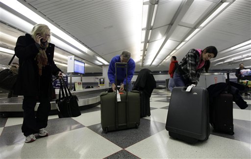 Travelers check their luggage at an United Airlines baggage claim area at O'Hare International Airport in Chicago.