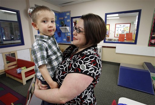 In this April 4, 2012, photo, Kelly Andrus holds her son Bradley in his classroom at Children's Choice Learning Centers Inc., in Lewisville, Texas. Bradley, who turns three in a couple of weeks, was diagnosed a year ago with mild autism. After $1 billion spent, scientists are closing in on possible causes of autism. (AP Photo/Tony Gutierrez)