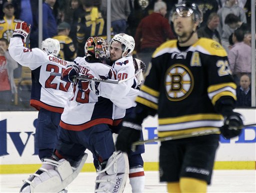 Boston Bruins center Chris Kelly (23) skates away as Washington Capitals goalie Braden Holtby (70); center Marcus Johansson (90), of Sweden; and left wing Jason Chimera (25) celebrate the Capitals' 2-1 win in overtime in Game 7 of an NHL hockey Stanley Cup first-round playoff series, in Boston on Wednesday, April 25, 2012. (AP Photo/Elise Amendola)