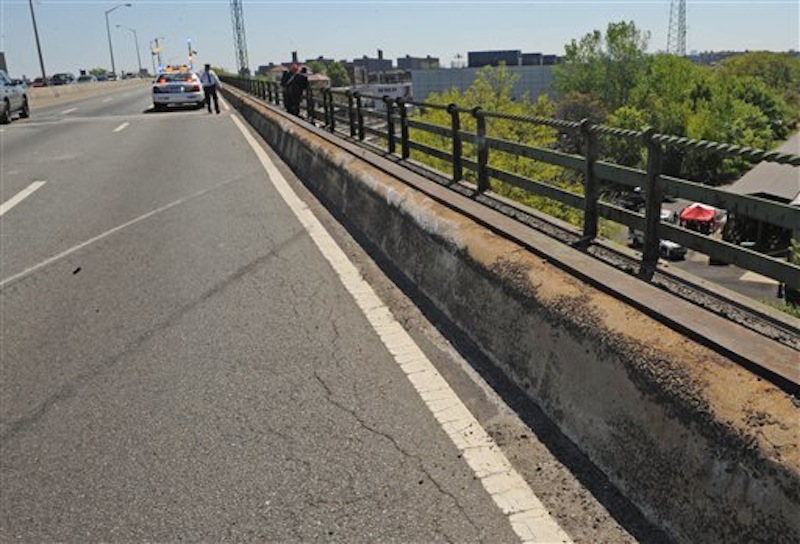 Skid marks and a scraped concrete barrier mark the spot where a van carrying seven occupants plunged off the highway to a wooded area below, Sunday April 29, 2012, in New York. Authorities say the out-of-control van plunged off a roadway near the Bronx Zoo, killing seven people, including three children. (AP Photo/ Louis Lanzano)