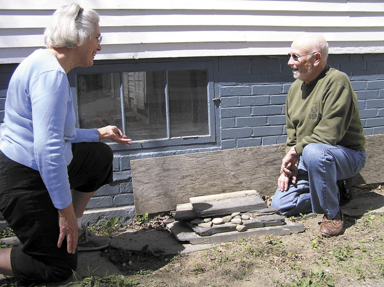 ENTRY POINT: State Rep. Thomas Longstaff and his wife, Cindy, on Thursday inspect the cellar window where a burglar gained entry to their house the previous day. Cindy Longstaff chased the woman burglar down the street, grabbed the computer that had been stolen from her husband’s office and told her to stay put until police arrived.