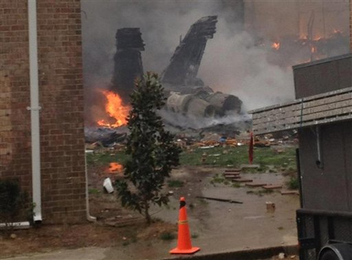 The fuselage of an F/A-18 Hornet burns after crashing into a residential building in Virginia Beach, Va., today.