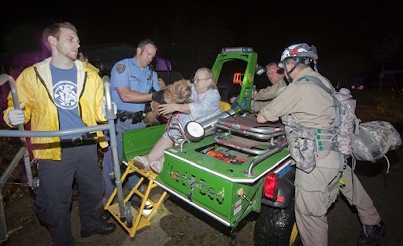 An elderly woman and her dog are taken out of the Pinaire Mobile Home Park in Wichita, Kan., after a tornado caused massive destruction in the area, on Saturday night, April 14, 2012. (AP Photo/The Wichita Eagle, Travis Heying)