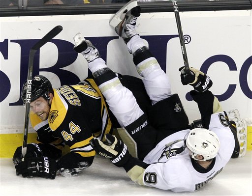 Boston Bruins defenseman Dennis Seidenberg (44) of Germany and Pittsburgh Penguins right wing Pascal Dupuis (9) crash along the boards during the third period of an NHL hockey game in Boston, Tuesday, April 3, 2012. The Penguins won 5-3.